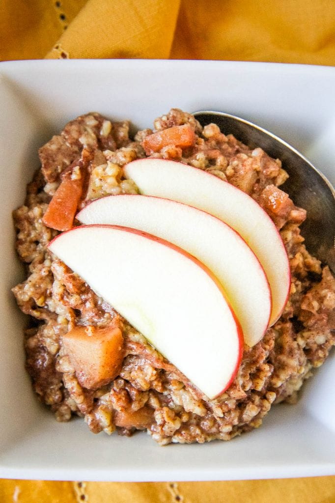 Overnight Slow Cooker Apple Cinnamon Steel Cut Oatmeal With Sliced Apples On Top