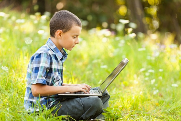 Boy using laptop outdoor