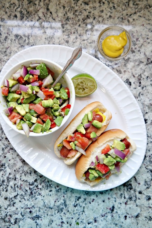Grilled hot dogs with avocado relish via Dine & Dish